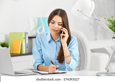 A Beautiful Successful Woman Talking On Phone At The Modern Office