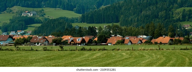 Beautiful summer in the European village - green field view on the background of country houses. High quality photo - Shutterstock ID 2109351281