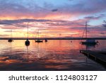 Beautiful summer evening nature background. Amazing summer evening landscape with group of drifting yachts on a lake Mendota during spectacular sunset. Bright sky reflects in the lake water.