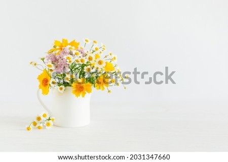 Beautiful summer flowers in a jar on a white background. Selective focus. Place for text.