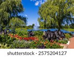 a beautiful summer landscape at Chicago Botanic Garden with a lake, lush green trees, plants and grass, blue sky and clouds in Glencoe Illinois USA