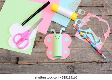 Beautiful summer paper cut butterfly, scissors, glue stick, colored paper sheets and scraps on wooden table. Kids creativity workplace. Summer kids paper art craft project in kindergarten, camp, home - Powered by Shutterstock