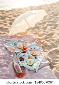 Beautiful Summer Picnic On The Beach At Sunset In Boho Style. Organic Fresh Fruit With Natural Lemonade On Linen Blanket With White Umbrella. Vegetarian Eco Idea For Weekend Picnic.