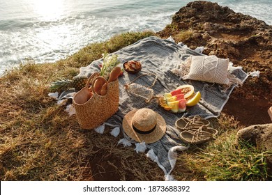 Beautiful summer picnic on the beach at sunset in boho style. Organic fresh fruit on linen blanket. Picnic background with basket, fruits and wicker bag with baguette - Powered by Shutterstock