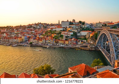 Beautiful summer sunset over the Douro river in Porto, Portugal. The dominants of the city are the Dom Luis I Bridge and the Porto Cathedral. Photo: August 31st 2018