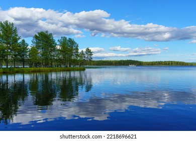 Beautiful summer view across the water of a large lake in Sweden, an old steam boat passing on the shiny water - Shutterstock ID 2218696621