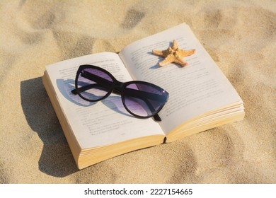 Beautiful sunglasses, book and starfish on sand - Powered by Shutterstock