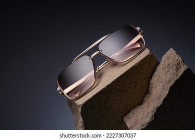 Beautiful sunglasses on a beautiful background with stones. Advertising your glasses. Gold frame glasses for women. Optical shop advertising background Fashion Vintage Style and product promotion