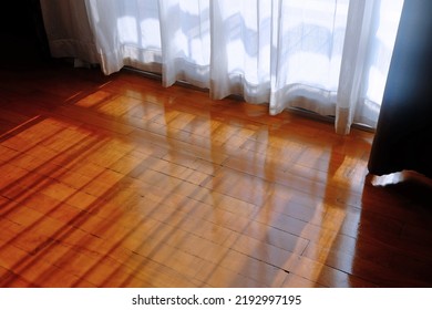 Beautiful Sunlight Through Window And White Curtain To The Shiny Wood Floor