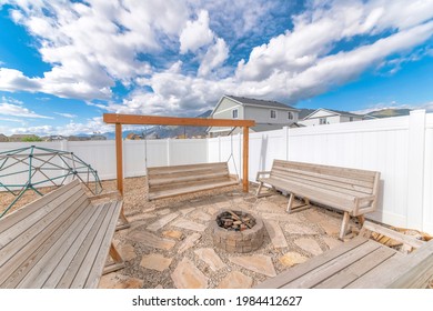 A Beautiful Sunny Backyard Idea With Wooden Benches And A Swing With A Fire Pit In The Middle