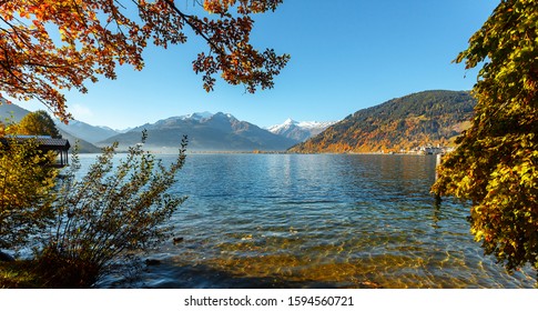 Beautiful Sunny Day In Alps. Wonderlust View Of Highland Lake With Autumn Trees Under Sunlight And Perfect Sky. Landscape With Alps And Zeller See In Zell Am See, Salzburger Land, Austria