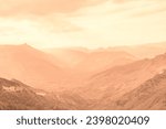 Beautiful sunny day in mountain valley and mountainous countryside landscape in summer toned in pantone color of year 2024 Peach Fuzz