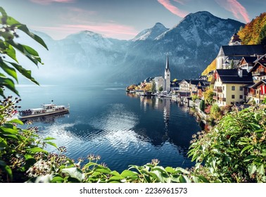 Beautiful sunny landscape of Hallstatt mountain village with Hallstatter lake and boat in Austrian Alps. Austria, Salzkammergut. Concept ideal resting place. Popular travel destination. postcard