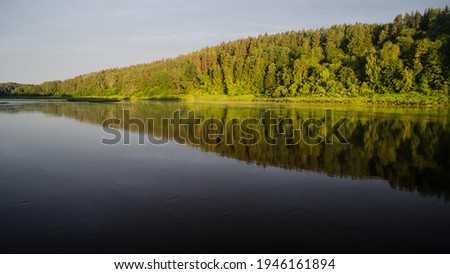 Beautiful sunny morning by the river Daugava. On the other bank of the river you can see the sunlit forest. Kraslava, Latvia