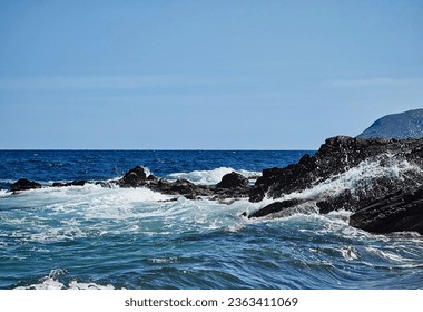 beautiful sunny oceanscape at rocky coastline lively waves blue sky