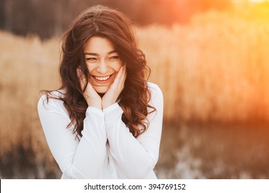 beautiful sunny portrait of a girl wearing white clothes. Face laughing woman outdoors with copy space