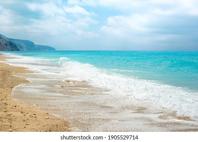 Beautiful sunny sea beach with amazing azure blue water and sky with fluffy clouds.