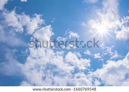 Beautiful Sunny Sky Background with White Clouds. Shining Sun at Clear Blue Sky. Summer Background with Sunlight and Clouds on Blue Sky.