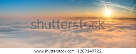 Similar – Image, Stock Photo The sun rises above the horizon, casting a warm glow over the misty mountains of Fuerteventura