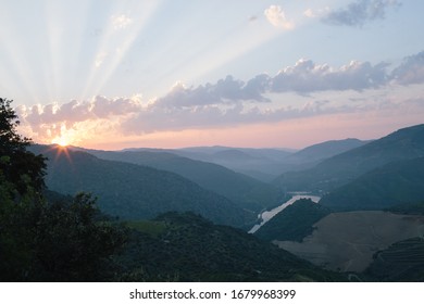 Beautiful Sunrise behind the mountains in Alto Douro Vinhateiro with the River Douro showing down on the hills