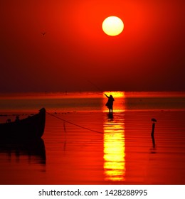 Beautiful Sunrise Over Water And Silhouette Of Old Woman Fishing