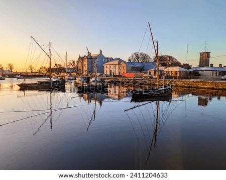 Beautiful sunrise scenery with old wooden boats Galway hookers reflected in water at Claddagh in Galway city, Ireland 