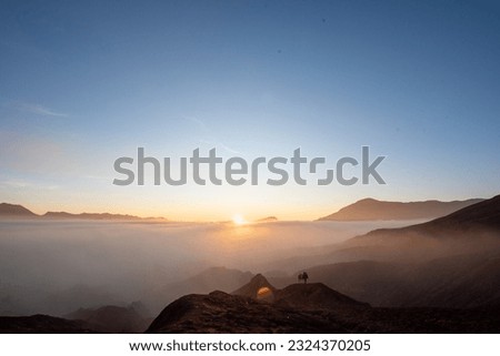 Beautiful sunrise scenery with silhouette horseman and his horse at Bromo Mountain, Bromo Tengger National Park