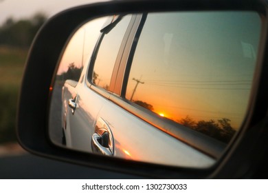 Beautiful Sunrise In Sideview Car Mirror On Forest Road.