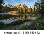 Beautiful sunrise at Stanley Lake in the Sawtooth Mountains of Idaho. Reflection in water with wildflowers