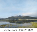 Beautiful sunrise with white clouds, big mountain, wide lake, place for camping in Chiang Mai 