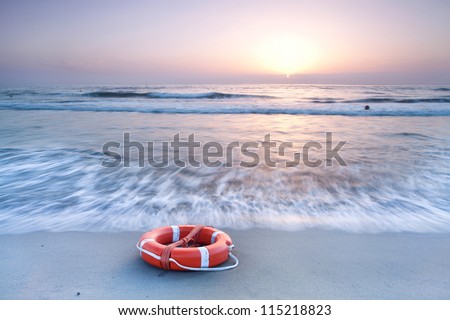 beautiful sunrise at white sand beach with a red lifebelt in foreground, Sardinia Costa Rei beach Porto Pirastu