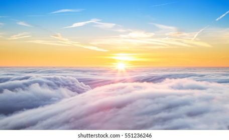 Beautiful sunset above clouds from airplane perspective. High resolution image