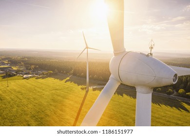 Beautiful sunset above the windmills on the field