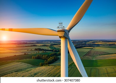 Beautiful sunset above the windmills on the field - Shutterstock ID 307407380