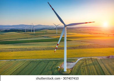 Beautiful sunset above the windmills on the field - Shutterstock ID 307407410