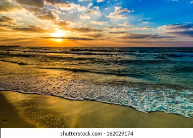 Beautiful Sunset At The Beach, Amazing Colors, Light Beam Shining Through The Cloudscape Over The Arabian Gulf Seascape, United Arab Emirates. Dubai Sea And Beach