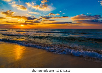 Beautiful Sunset At The Beach, Amazing Colors, Light Beam Shining Through The Cloudscape Over The Arabian Gulf Seascape, United Arab Emirates. Dubai Sea And Beach