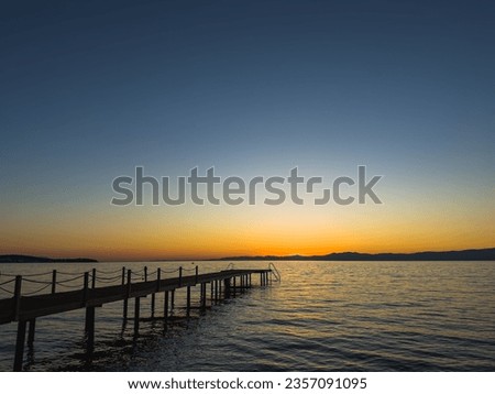 Beautiful sunset beach with olive tree and pink sky for travel and vacation in holiday relax time , bridge into the sea at sunset. High quality photo