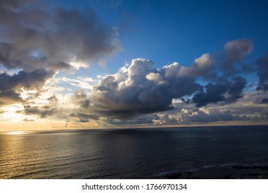 Beautiful sunset with blue sky and dense clouds above sea
