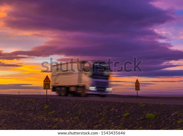 \
Beautiful sunset with\
blurry truck on the road. Midnight sun of Iceland. Visit Iceland.\
Beauty world.