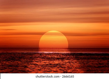 주황색 색깔의 해변 옆의 아름다운 일몰 스톡 사진