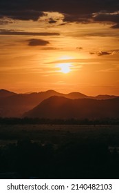 Beautiful Sunset In Carpathian Mountains, Ukraine. Warm Orange Light, Sky, Dark Silhouette. Traveling In Summer. No People. Vertical Photo.