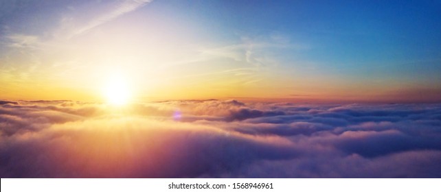 Beautiful sunset cloudy sky from aerial view. Airplane view above clouds - Shutterstock ID 1568946961