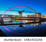Beautiful Sunset Clyde Arc Bridge across river in Glasgow, Scotland, UK. It is nice weather with reflection on water, blue sky, lights from buildings in downtown, skyline, attractions.    