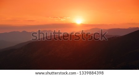 Beautiful sunset colors over the mountains of Peloponnese, Greece. Sun setting after hot summer day.