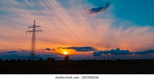 Beautiful sunset with dramatic clouds and powerlines near Tabertshausen, Bavaria, Germany