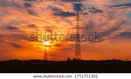 Beautiful sunset with dramatic clouds and powerlines near Tabertshausen, Bavaria, Germany