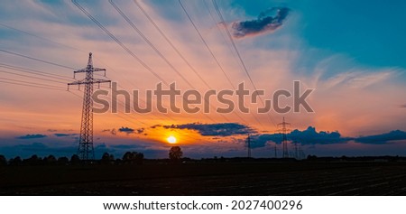 Beautiful sunset with dramatic clouds and powerlines near Tabertshausen, Bavaria, Germany