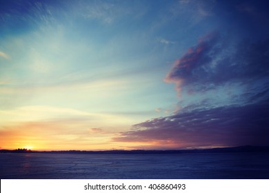 A Beautiful Sunset During Spring Time In Finland. Some Ice Is On The Lake And Clouds Are In The Sky. Image Has A Vintage Effect Applied.