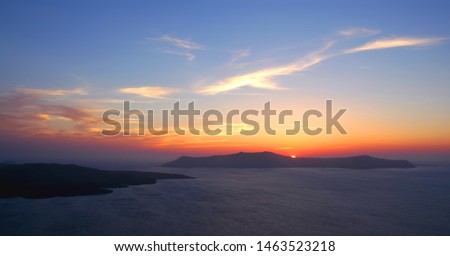 A beautiful sunset from Fira, Santorini Greece. This Santorini sunset is over the caldera to the setting sun. Santorini is famous for its sunsets. Fira, Santorini, sunset, night sky, pretty red clouds